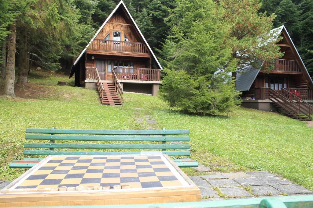a wooden house with a chess board in front of a house at OW Wisan in Baligród
