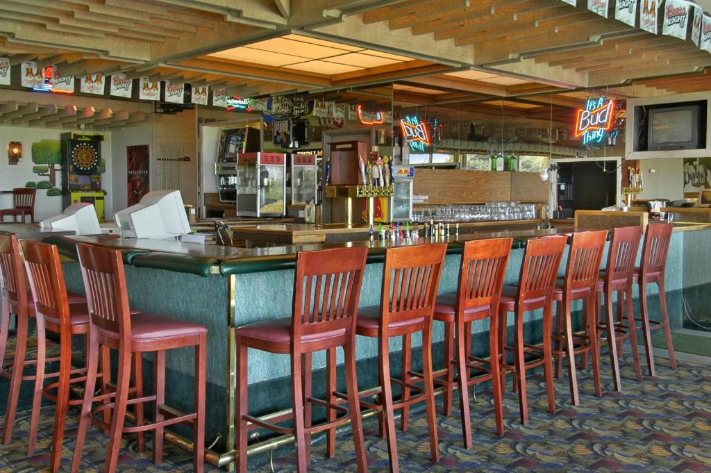 a bar with a row of orange chairs at a restaurant at Red Lion Hotel Pendleton in Pendleton