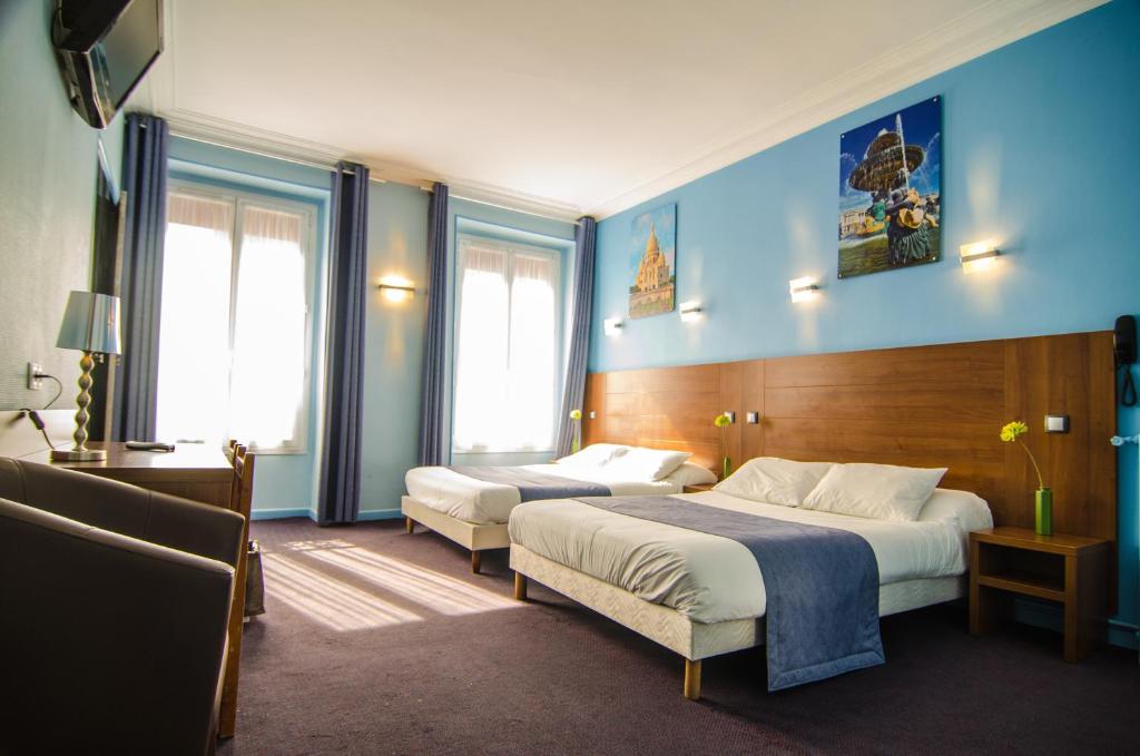 1 dormitorio con 2 camas y paredes y ventanas azules en Hotel Paris Bruxelles en París