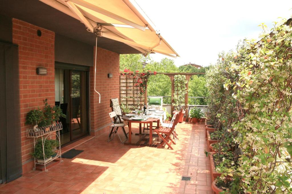 a patio with a table and chairs and an umbrella at Terrace22 - Delizioso attico ben collegato, 4 persone in Rome