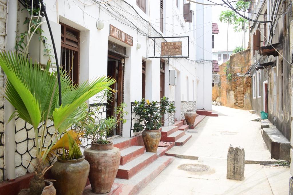 an alley with potted plants on the side of a building at Karibu Inn in Zanzibar City