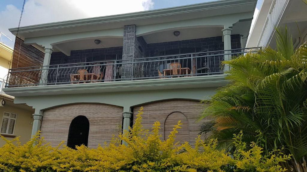 ein Haus mit einem Balkon mit Stühlen darauf in der Unterkunft Luna Blue Residence in Trou aux Biches