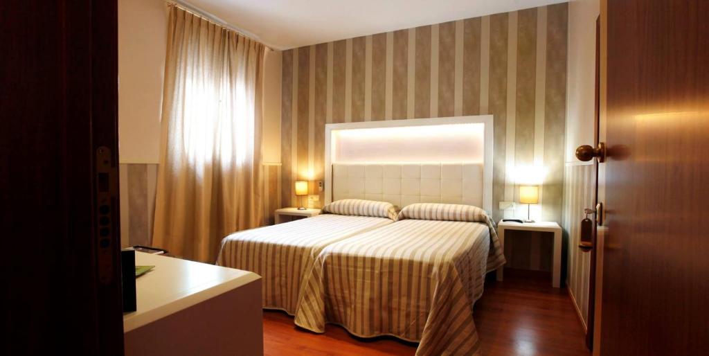 a hotel room with a bed and a window at Hostal Paris in San Fernando