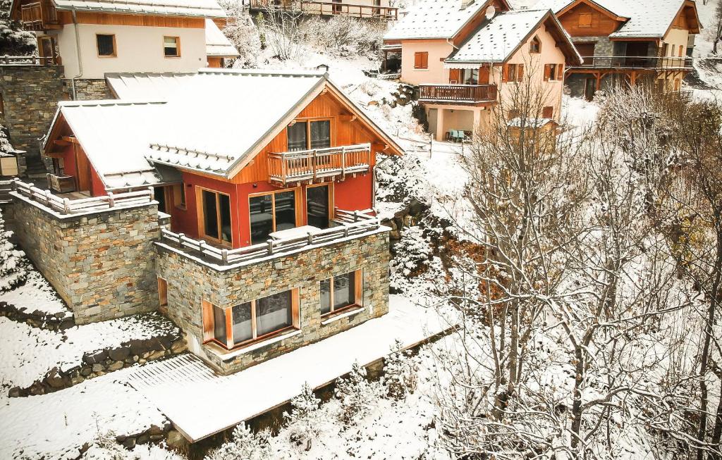 dom pokryty śniegiem w mieście w obiekcie Odalys Chalet le Pure Altitude w mieście Valloire