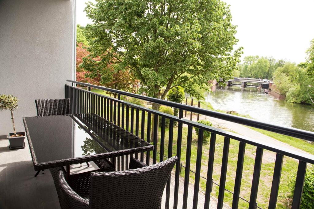 a balcony with a table and chairs with a view of a river at Spreehaus-Apartments in Lübben