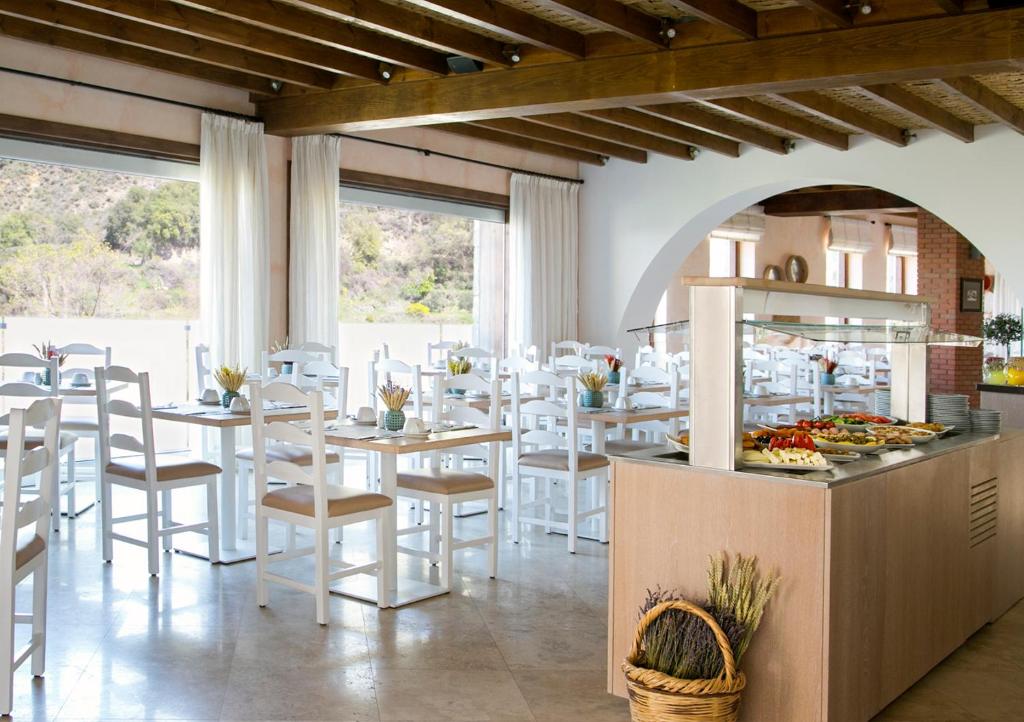 a restaurant with white chairs and tables and a buffet at Casale Panayiotis in Kalopanayiotis