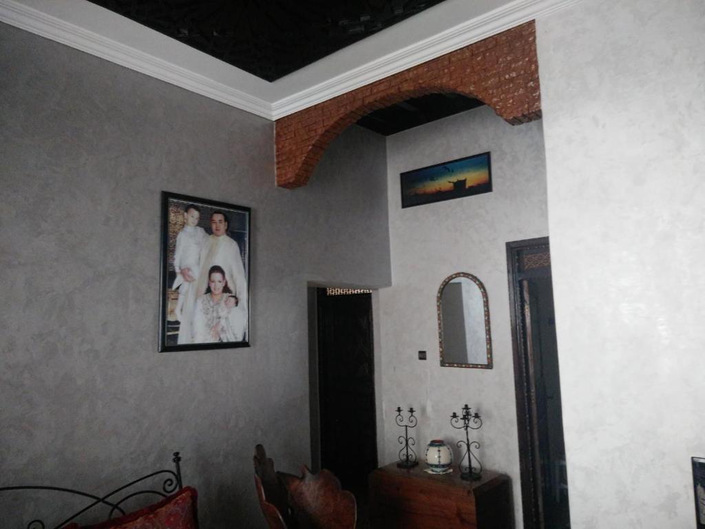 um quarto com fotos de uma noiva e um noivo na parede em Hotel Coeur de Mogador em Essaouira