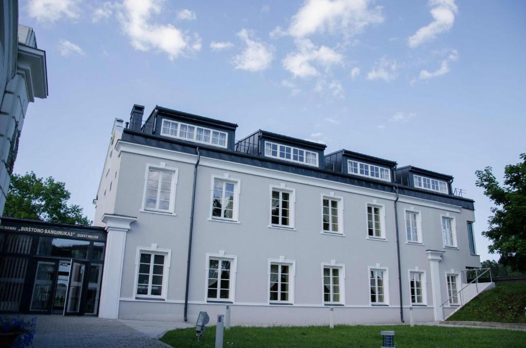 a large white building with windows on top of it at Birštono Banginukas in Birštonas