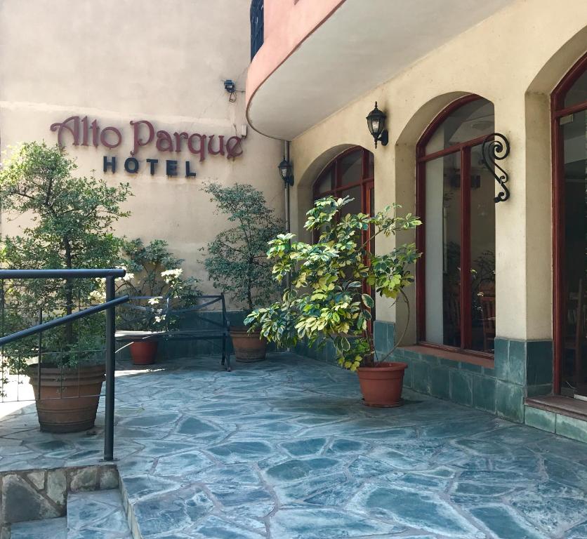 a hotel with potted plants in front of a building at Altoparque Hotel Salta in Salta