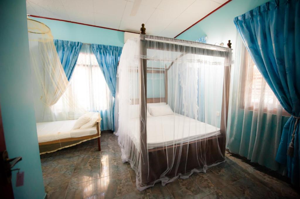 a bedroom with a canopy bed and blue walls at Dream Villa in Mirissa