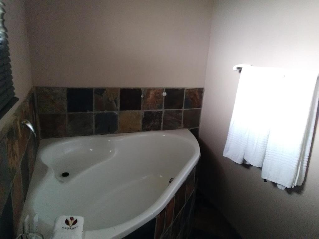 a white bath tub in a bathroom with a window at Noma-Nini Lodge in White River