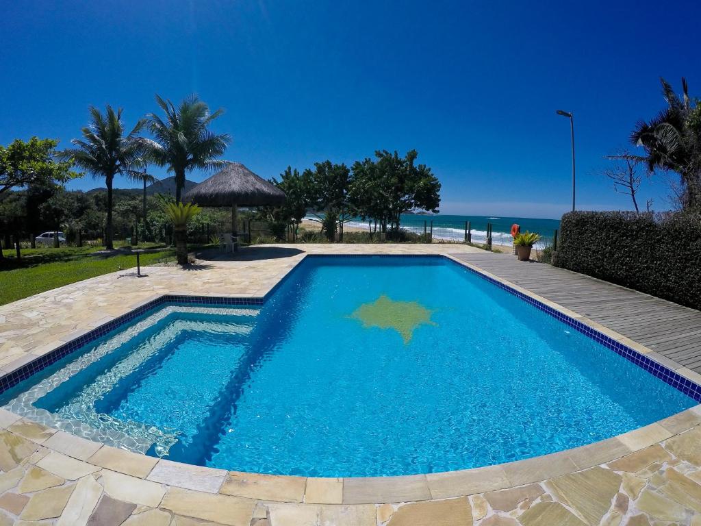 una piscina con el océano en el fondo en O Costão do Sol, en Balneário Camboriú