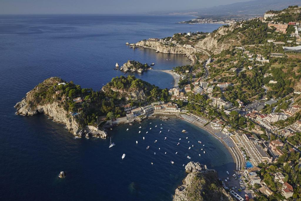 a large body of water with several boats in it at Villa Sant'Andrea, A Belmond Hotel, Taormina Mare in Taormina