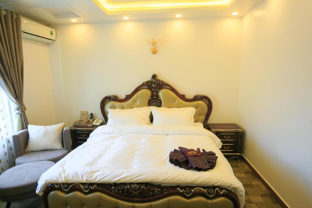 a bedroom with a large bed with white sheets at Pham Ha Hotel in Hai Phong