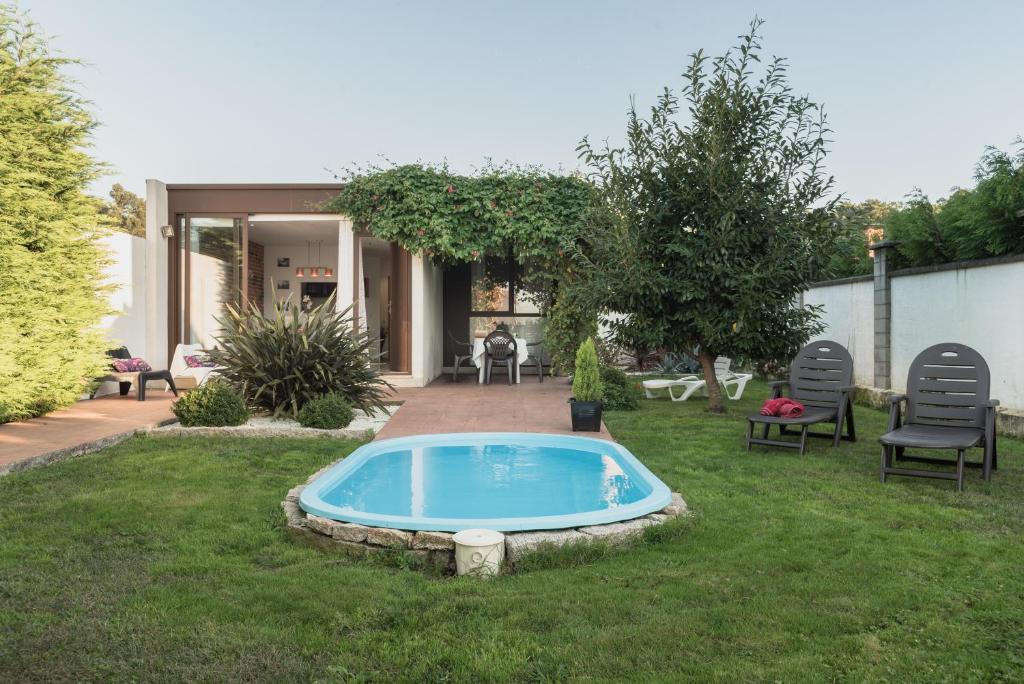 a backyard with a swimming pool in the grass at Casa Rural Viña Vella in Esteiro