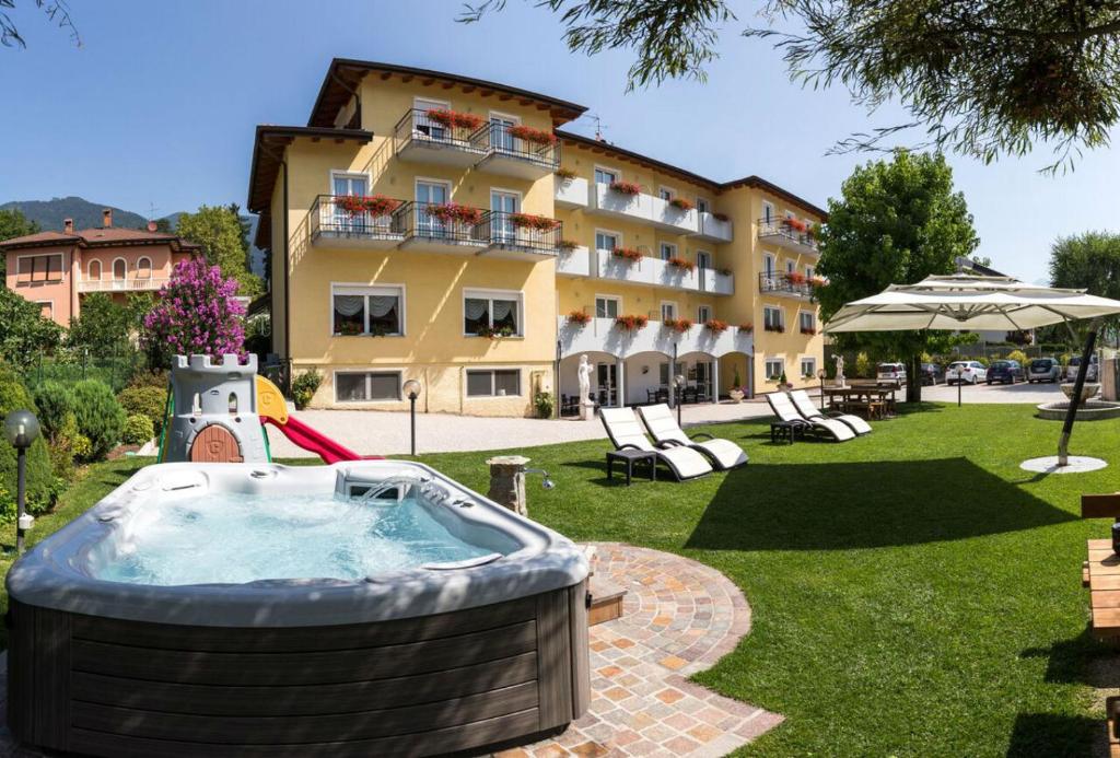a hot tub in a yard next to a building at Hotel Daniela in Levico Terme