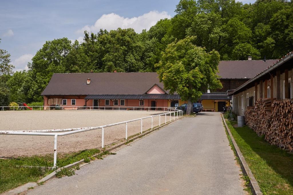 a barn with a white fence in front of a horse arena at Penzion Hradisko in Rožnov pod Radhoštěm