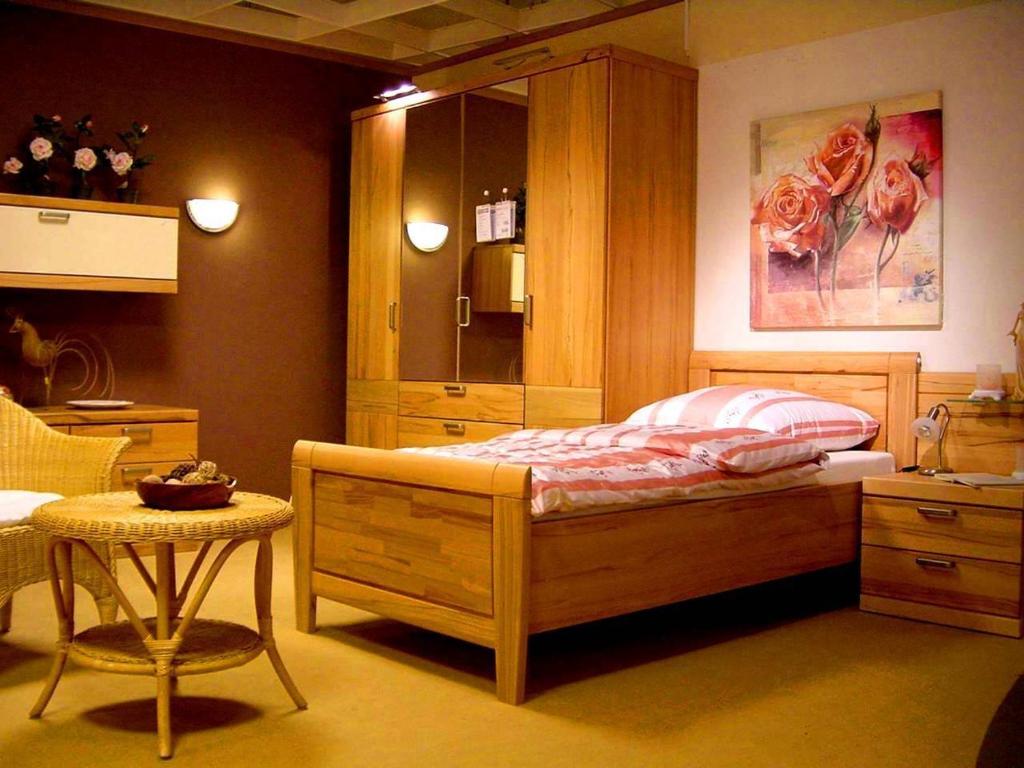 a bedroom with a bed with a cabinet and a table at Forsthaus Appartements in Braunschweig