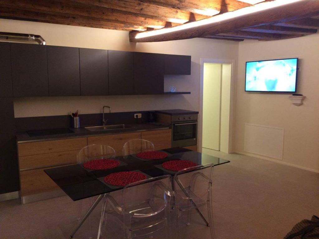 uma cozinha com uma mesa e cadeiras e uma televisão em Gioiello di Venezia, Suite San Lio em Veneza