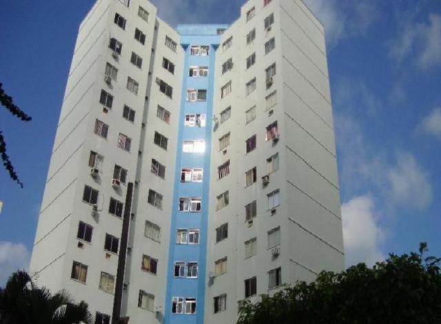 un edificio alto y blanco con muchas ventanas. en Apartamento Rio Centro, en Río de Janeiro