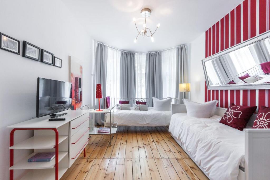 sala de estar con 2 camas y TV en Elegantes 2-Zimmer-Apartment im Kiez von Prenzlauer Berg en Berlín