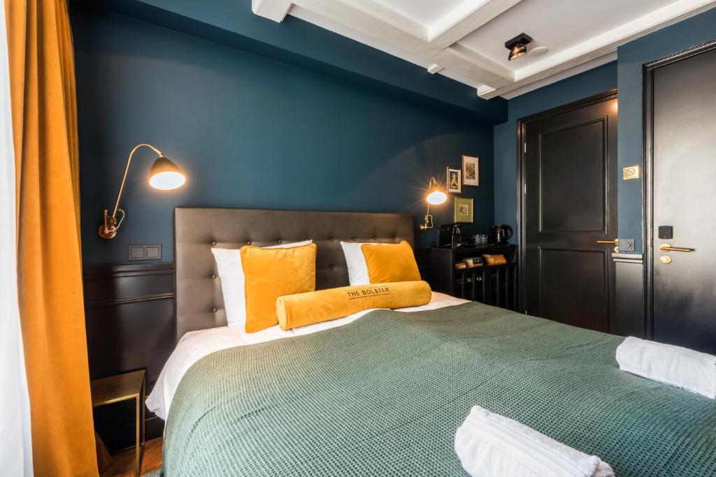 a blue bedroom with a large bed with orange pillows at The Bolster in Amsterdam