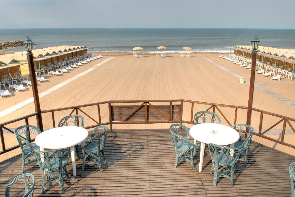 a boardwalk with tables and chairs on a beach at Manantiales Club de Mar in Mar del Plata