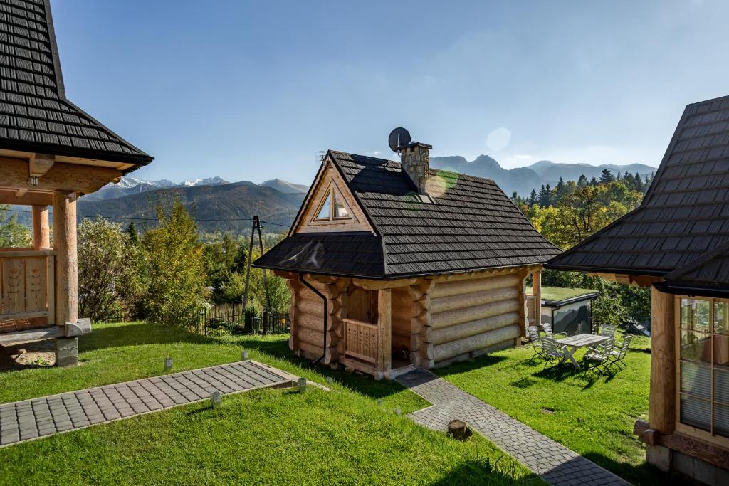 a small log cabin with a roof at Domki pod Gubałówką in Zakopane