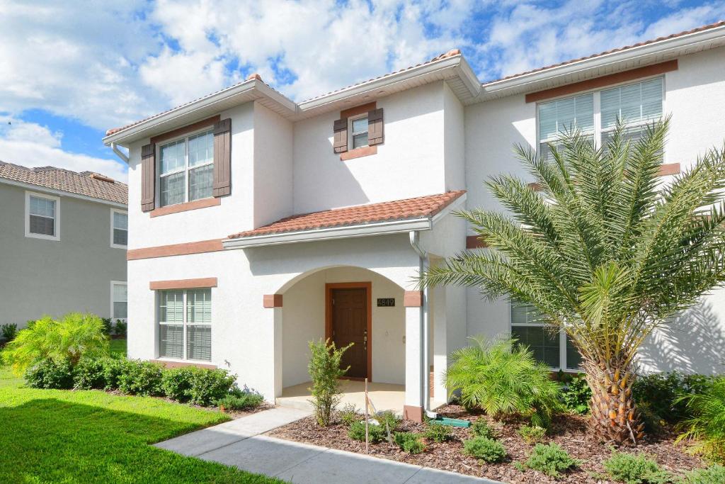 a house with a palm tree in front of it at Five Bedrooms TownHome with Pool 4849 in Kissimmee