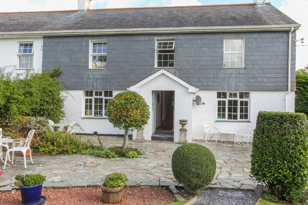 una casa blanca con un patio delante en Treweens, en Wadebridge