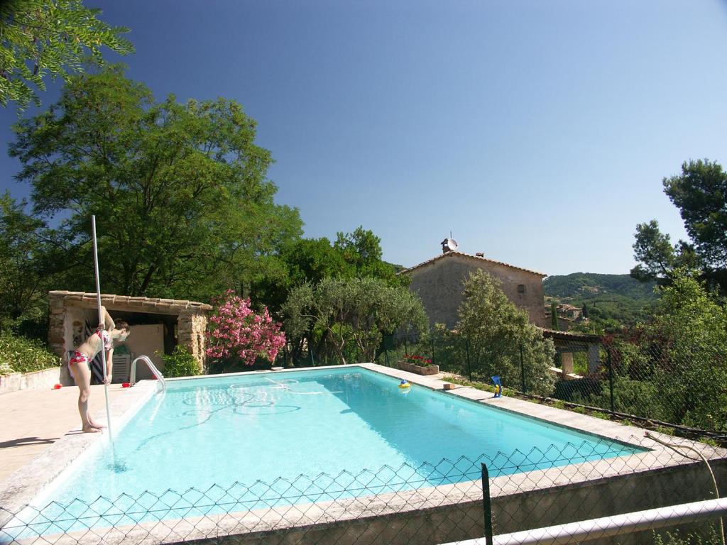 Un homme se tient à côté d'une piscine dans l'établissement Gîtes du Mas Icard, à Anduze