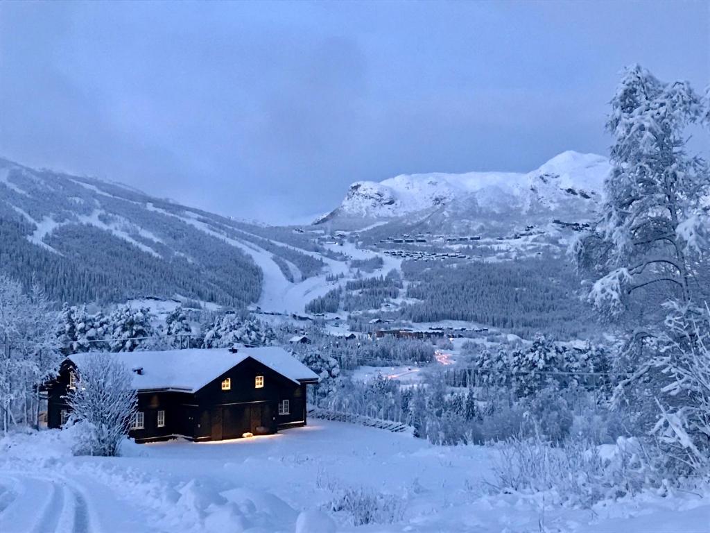 een hut in de sneeuw met een berg bij Kirkebøen Hytter in Hemsedal