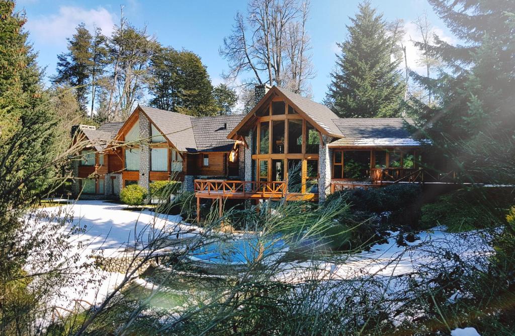 Ein Haus im Wald mit Schnee auf dem Boden in der Unterkunft Aldea Bonita in Villa La Angostura