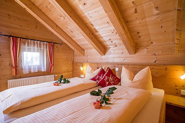 A bed or beds in a room at Achenseer Hüttendörfl