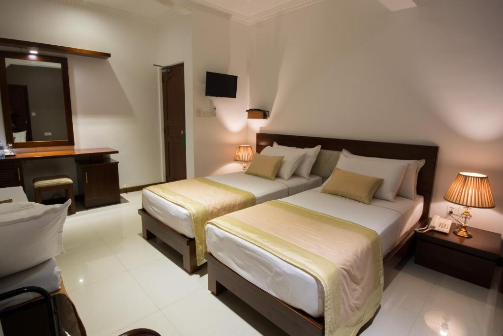 Postel nebo postele na pokoji v ubytování Ceyloni City Hotel