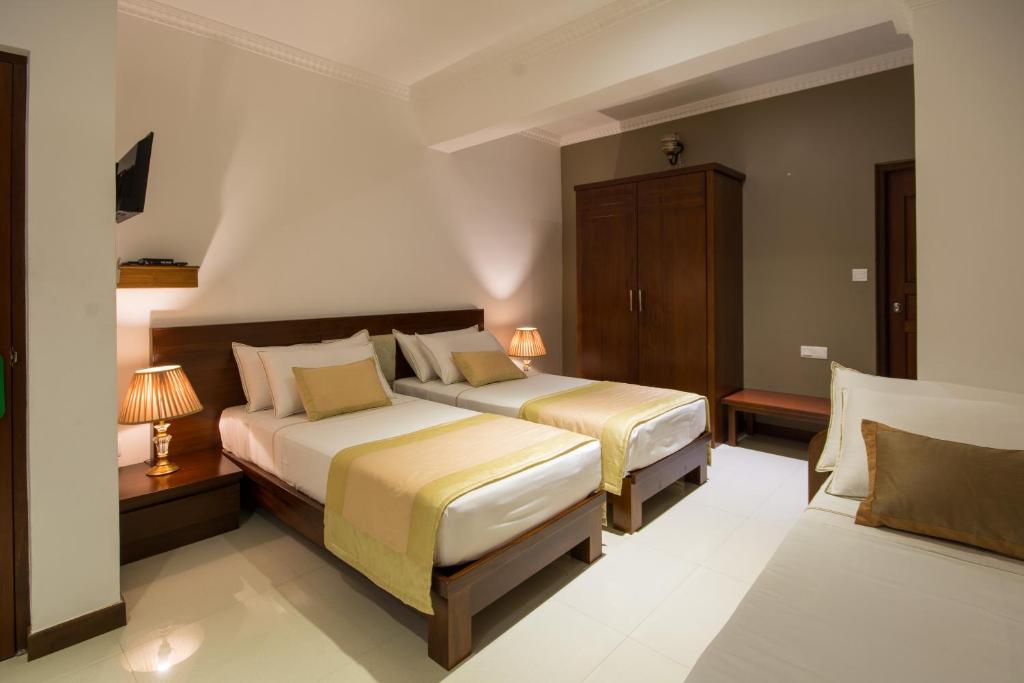 Postel nebo postele na pokoji v ubytování Ceyloni City Hotel