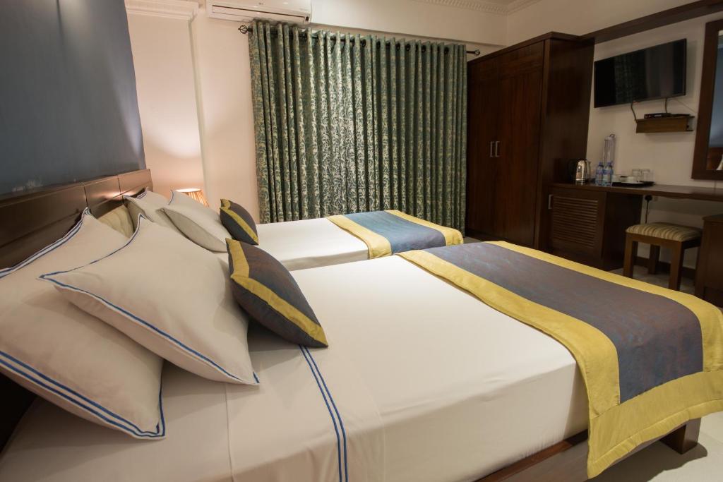 Postel nebo postele na pokoji v ubytování Ceyloni City Hotel