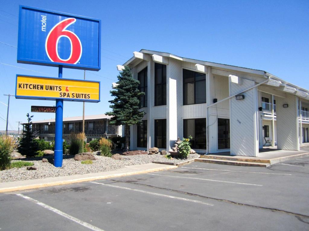 a building with a sign in a parking lot at Motel 6-Madras, OR in Madras