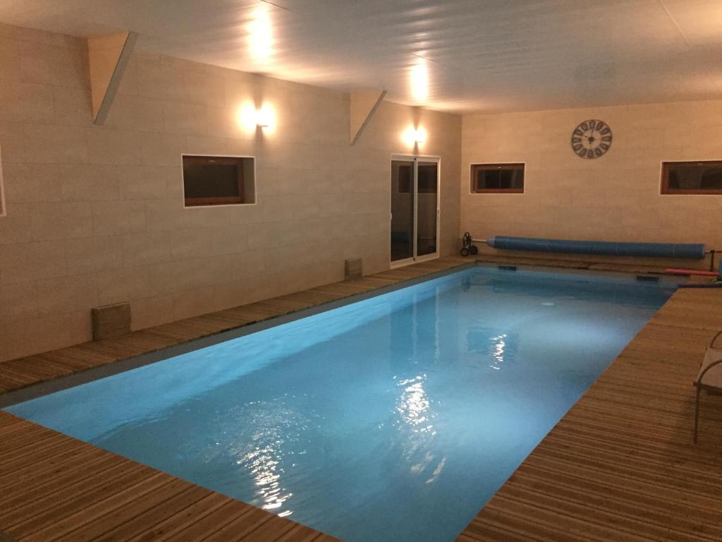 una grande piscina con acqua blu in un edificio di Chambres d'hôtes Penker a Minihy-Tréguier