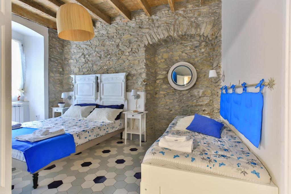 a bedroom with two beds and a stone wall at Mare amore @ Riomaggiore in Riomaggiore