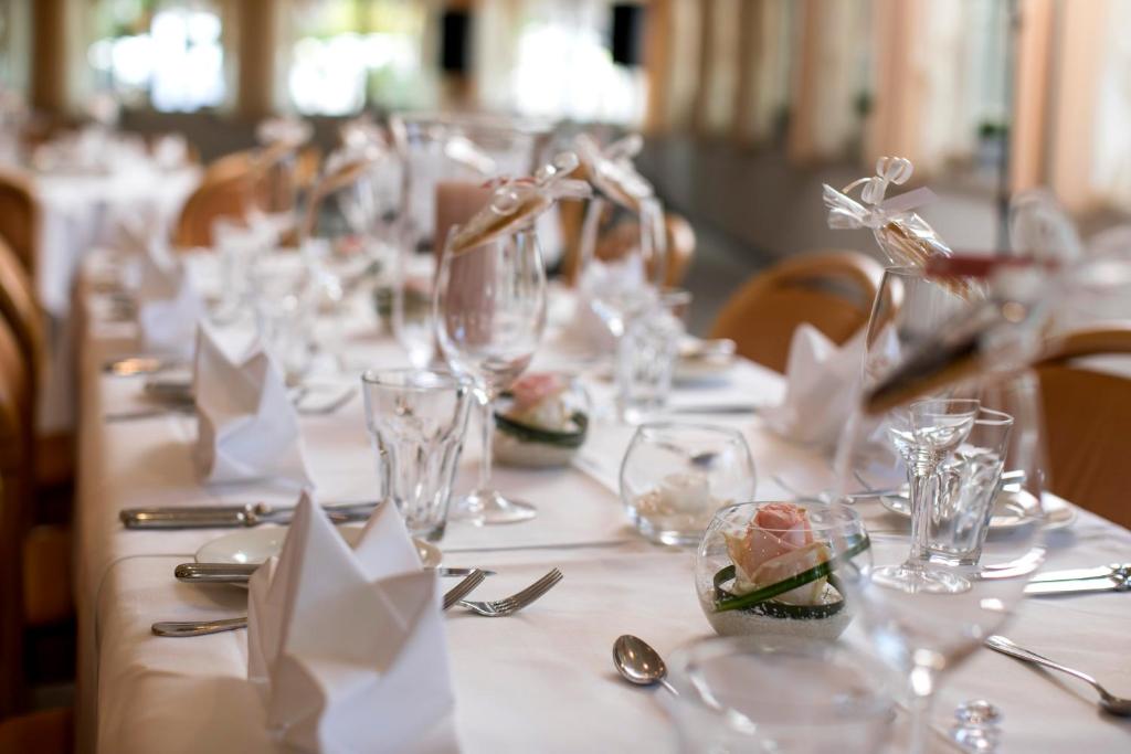 a long table with glasses and napkins on it at Hotel Winkelried am See in Stansstad