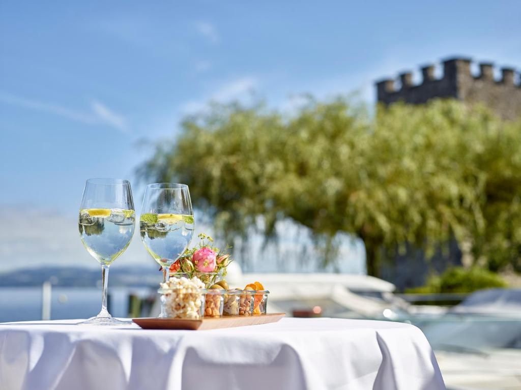 two glasses of white wine sitting on a table at Hotel Winkelried am See in Stansstad