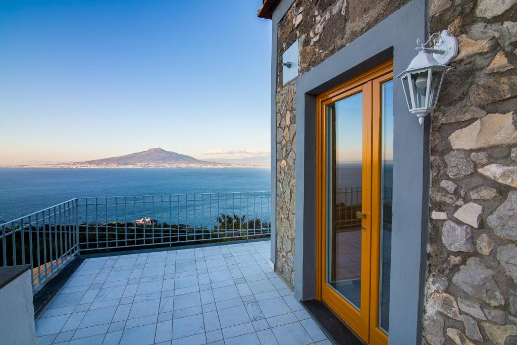 ヴィーコ・エクエンセにあるVilla Mariagiovannaの海の景色を望むバルコニー付きの家