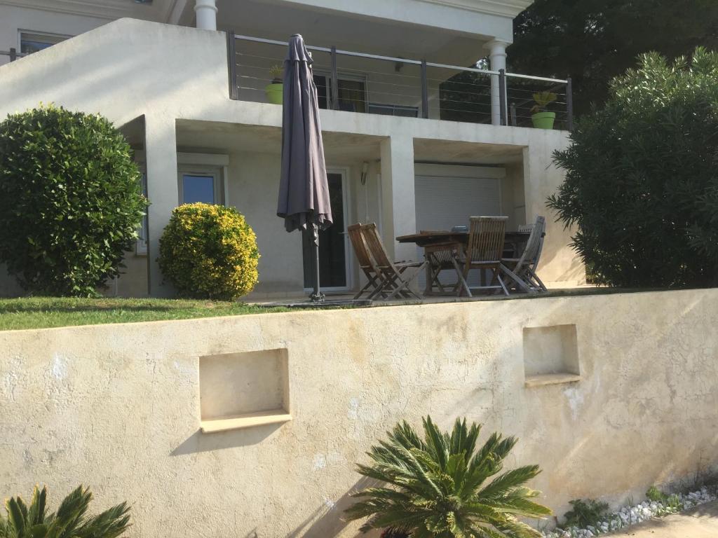 a patio with an umbrella and a table and chairs at Le Gîte du DAB in La Cadière-dʼAzur