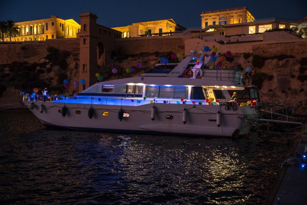a boat with lights on the water at night at Riti Yacht in Kalkara