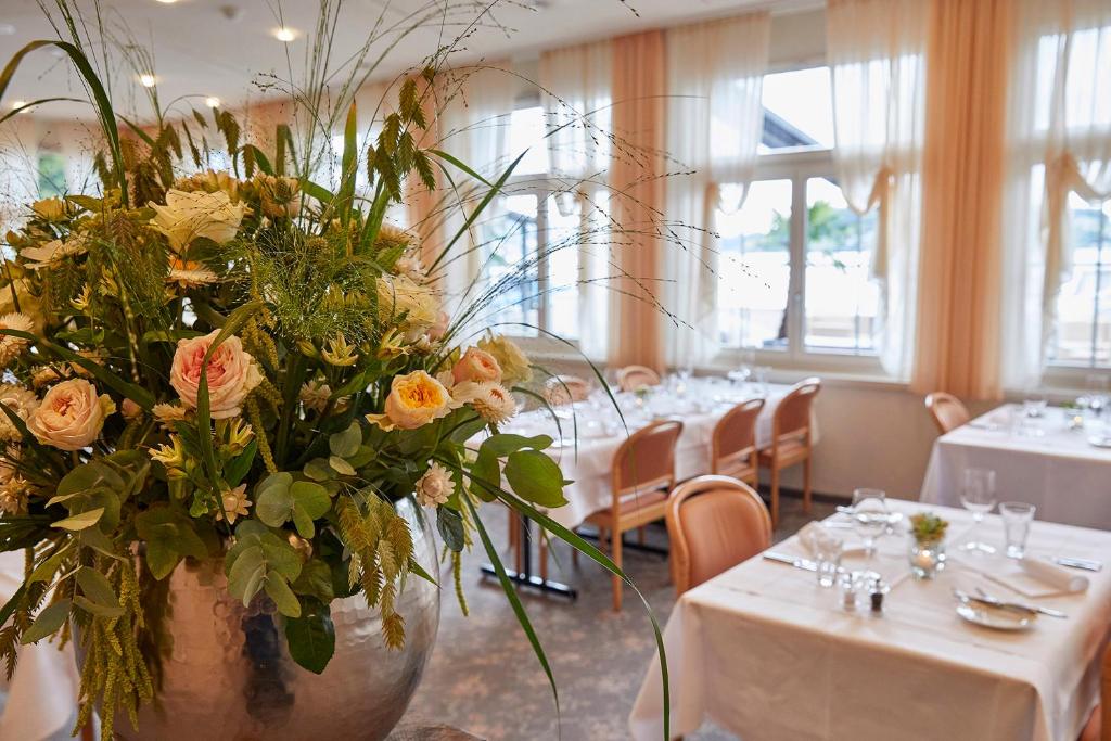 a large vase filled with flowers in a restaurant at Hotel Winkelried am See in Stansstad