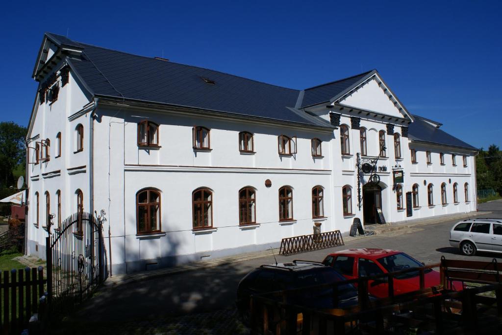 een groot wit gebouw met een zwart dak bij Maršovská Rychta in Nové Město na Moravě