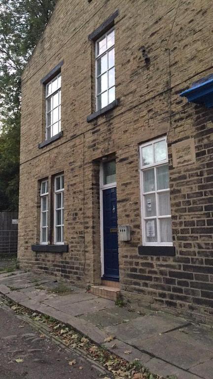 a brick building with a blue door and windows at Gateway Lodge in Cleckheaton