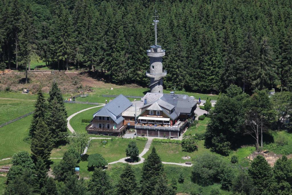 einen Luftblick auf ein großes Haus mit einem Uhrturm in der Unterkunft Berggasthof & Hotel Brend in Furtwangen