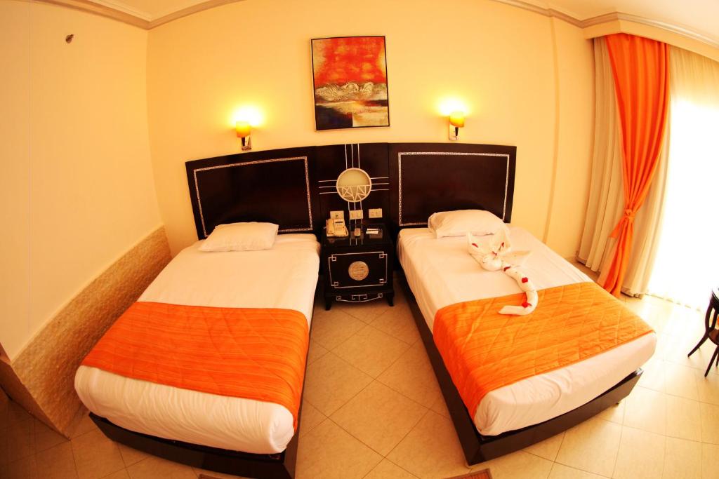 Postel nebo postele na pokoji v ubytování Sphinx Aqua Park Beach Resort